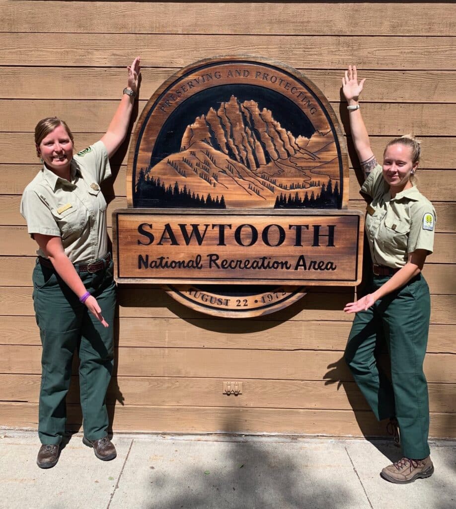 Park rangers in front of sign