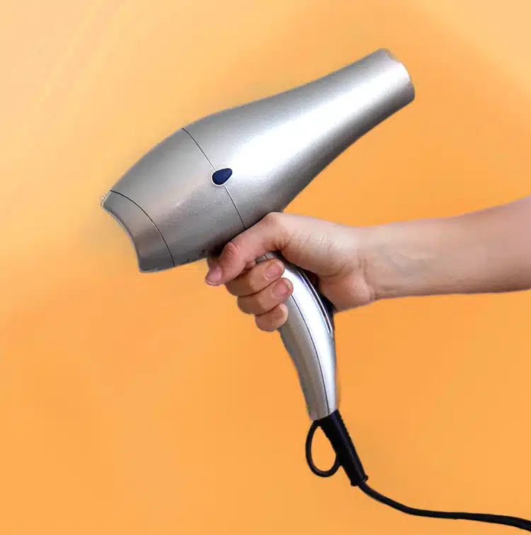 persons hand holding hair dryer
