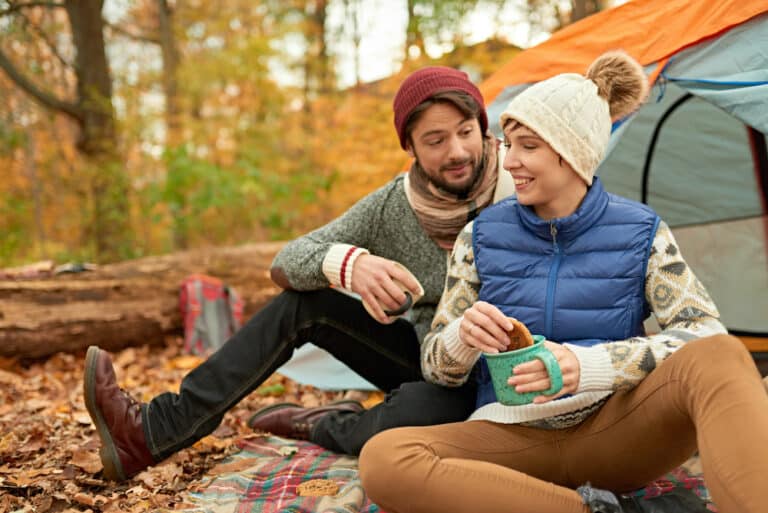 campers sitting at camp site in the fall