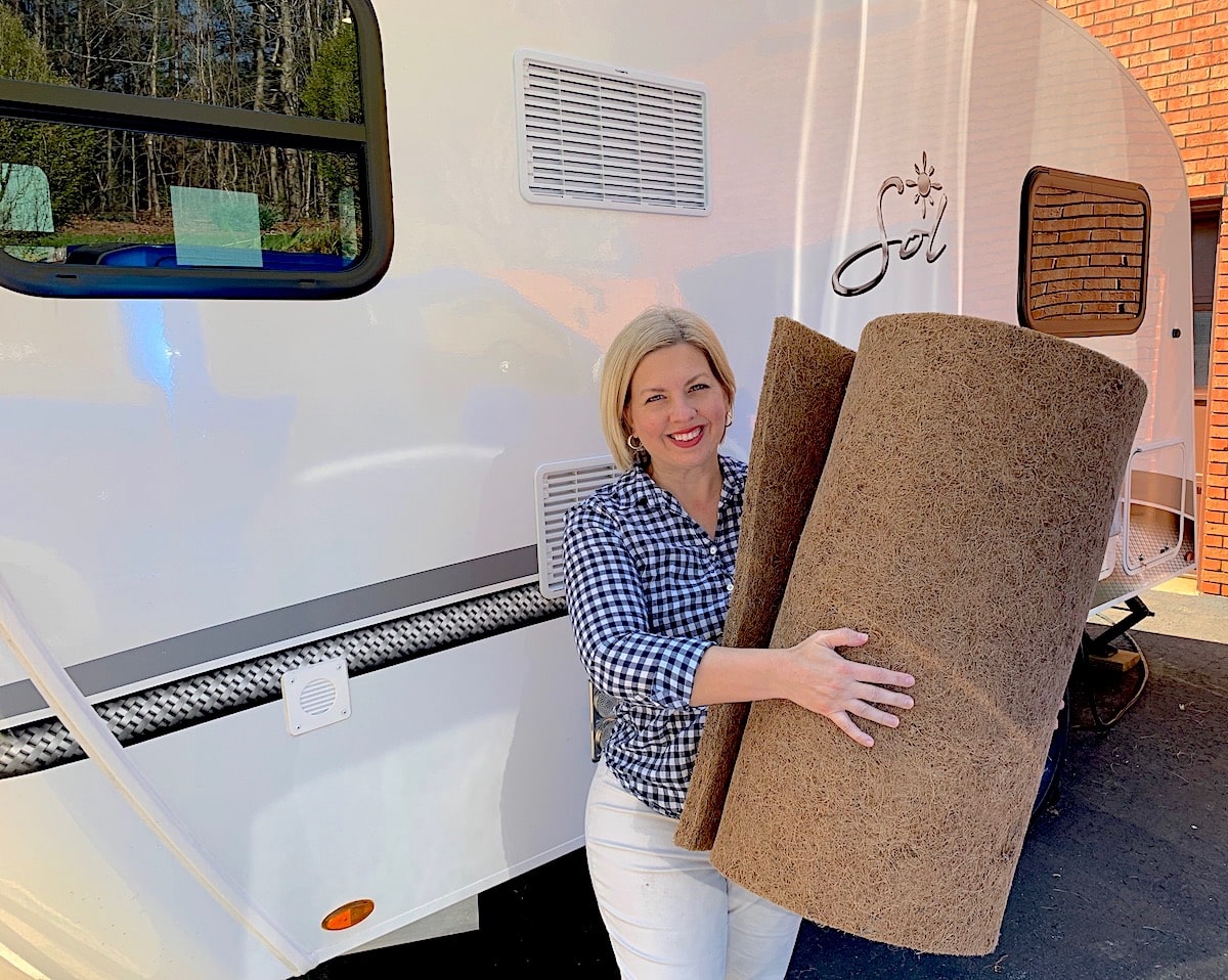 woman holding coir bed mat next to RV