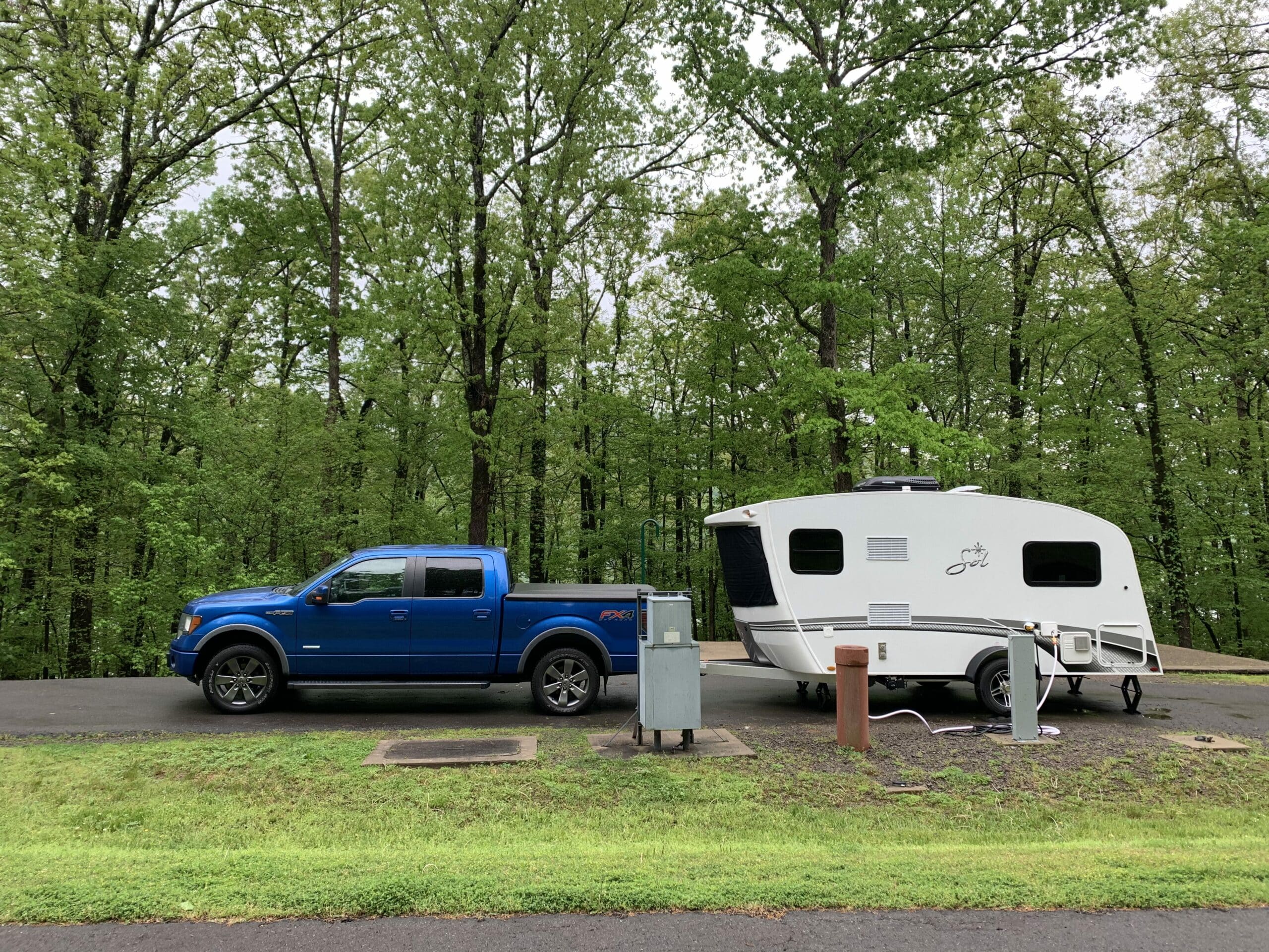 truck and small travel trailer parked in campsite
