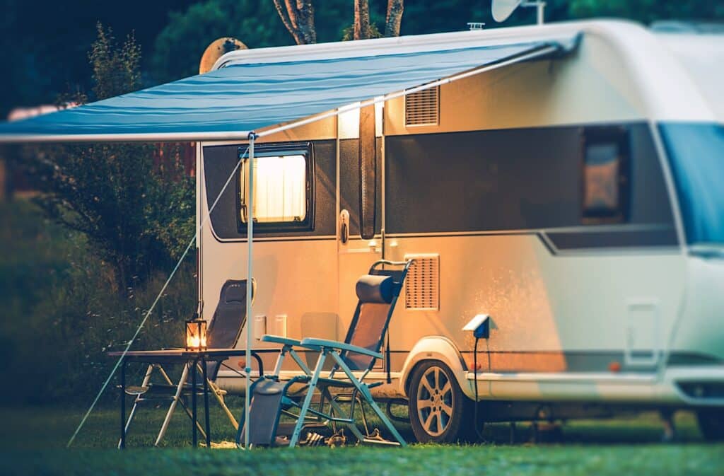 RV Awning At Dusk With Camping Chairs and table