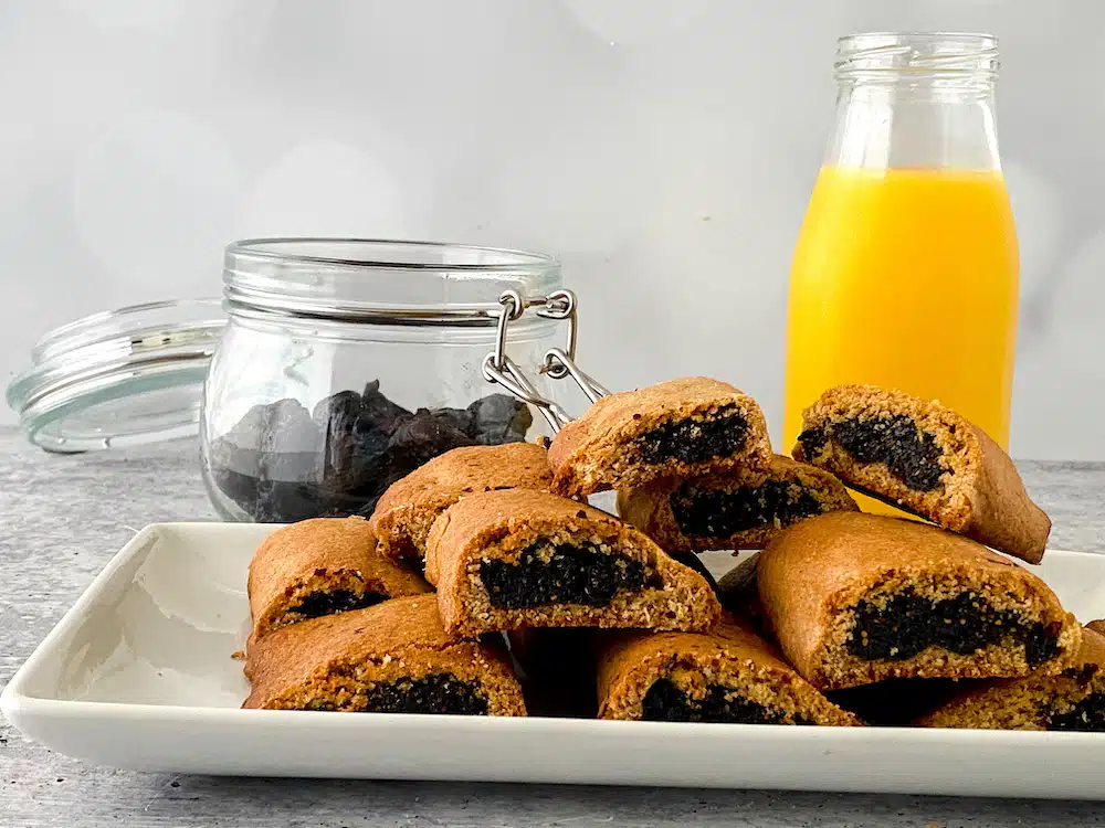 Copycat Fig Newtons on plate with orange juice in glass bottle in background