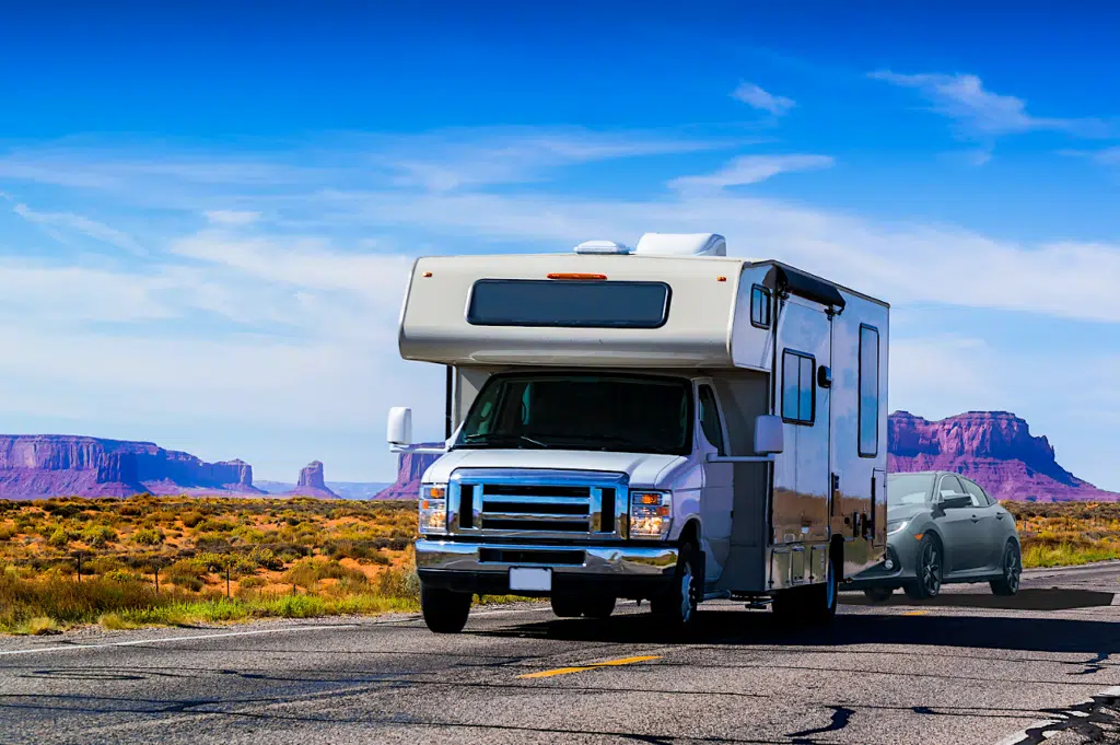 Class C Motorhome Towing a Car on a desert road