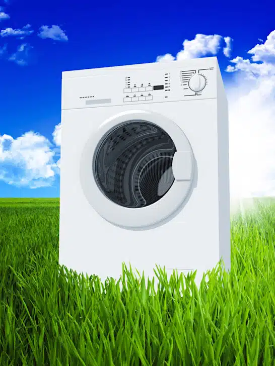 washing machine in green field with blue sky