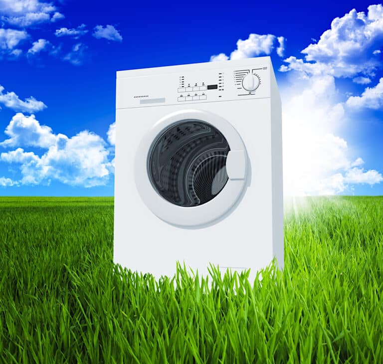 washing machine in green field with blue sky