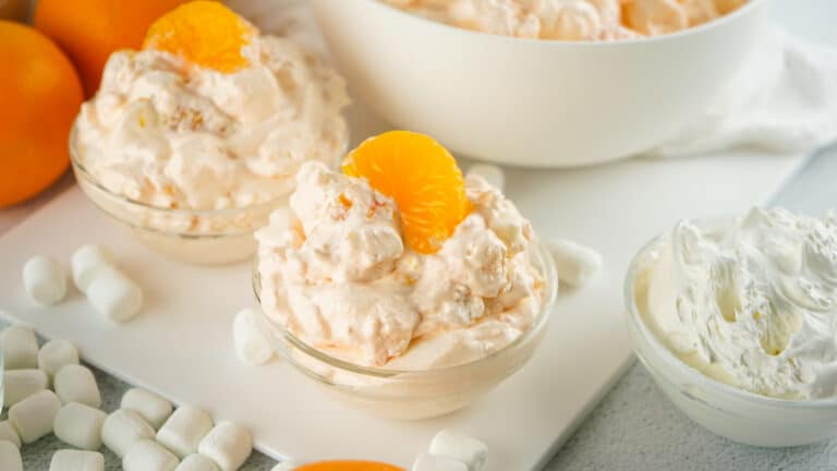 two small bowls filled with orange creamsicle salad topped with mandarin oranges
