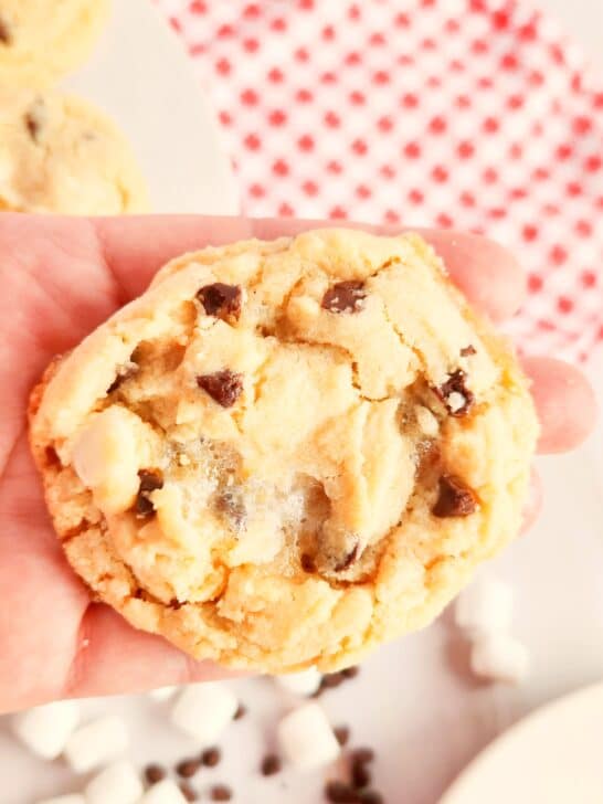 smores cookie in a woman's hand held over a red and white gingham check napkin