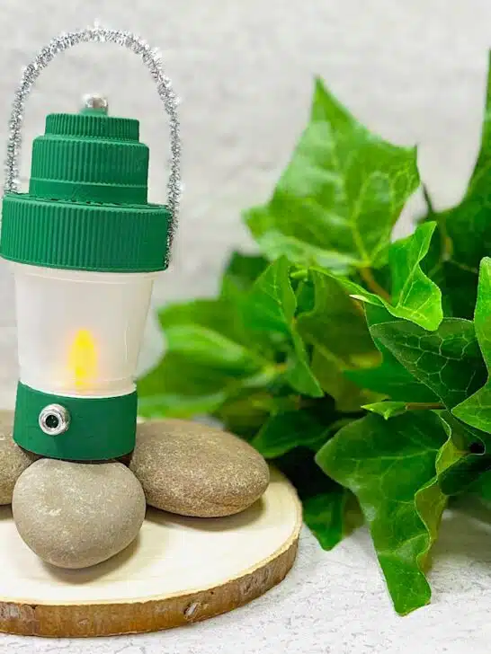DIY Camping Lantern On Log With Rocks and green leaves