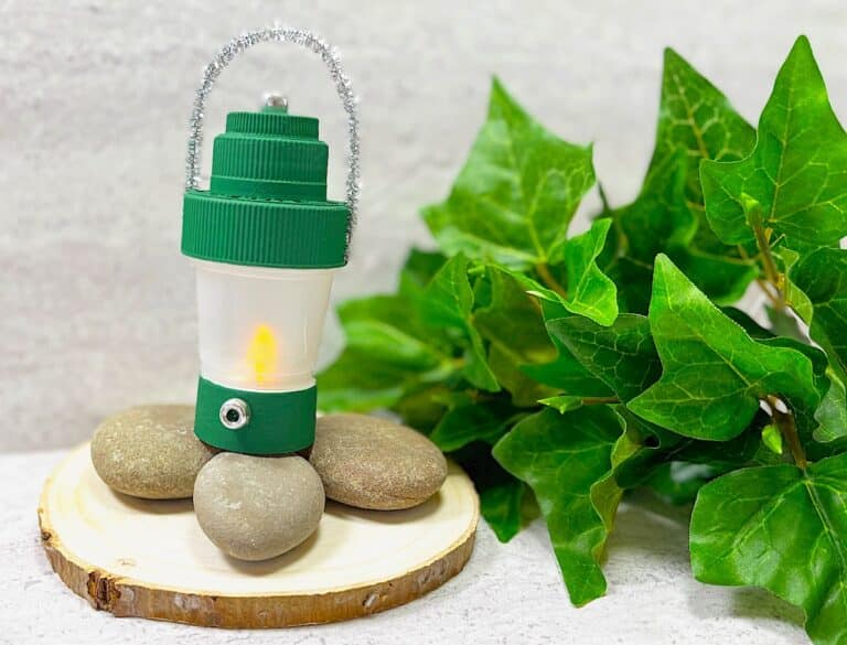 DIY Camping Lantern On Log With Rocks and green leaves