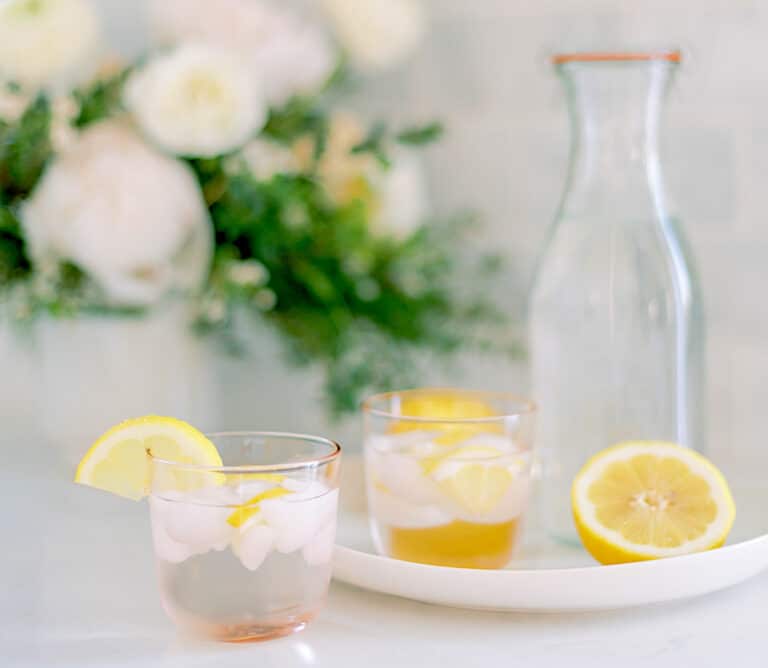 ice in glasses with lemon wedge on table with karaf