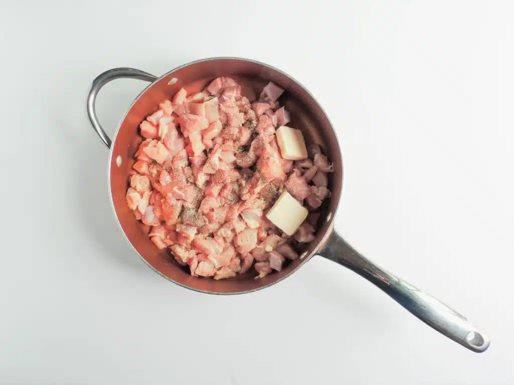 A frying pan filled with meat and vegetables.