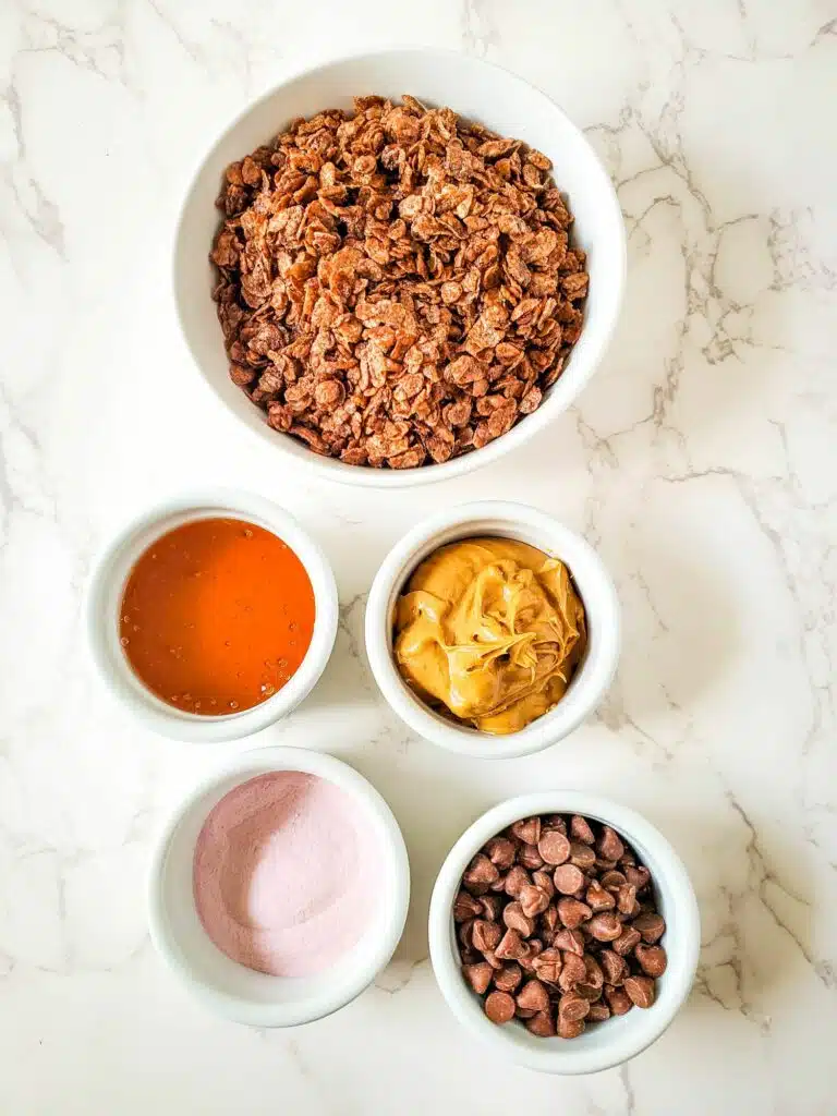 Chocolate granola ingredients on a marble countertop.