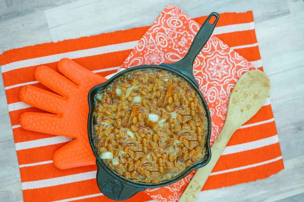 A cast iron skillet filled with pasta on a table.