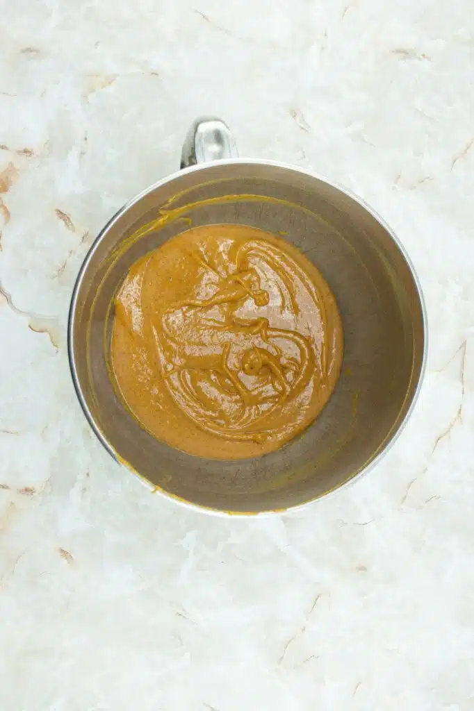 A bowl of peanut butter on a marble surface.