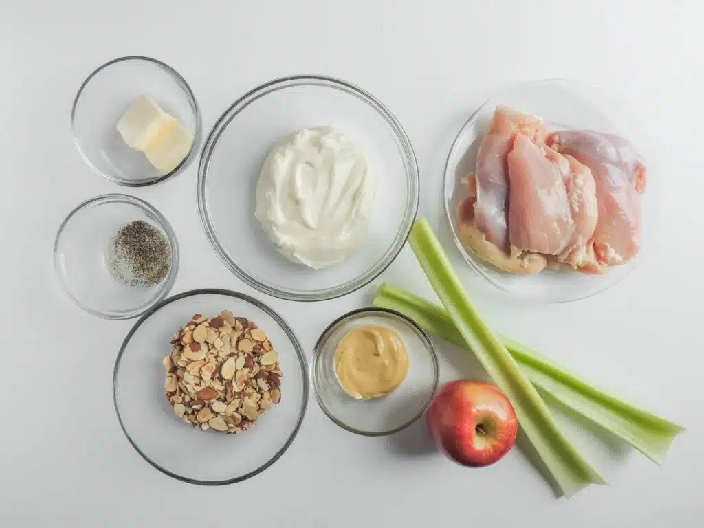 A bowl of chicken, celery, apples and yogurt on a white background.