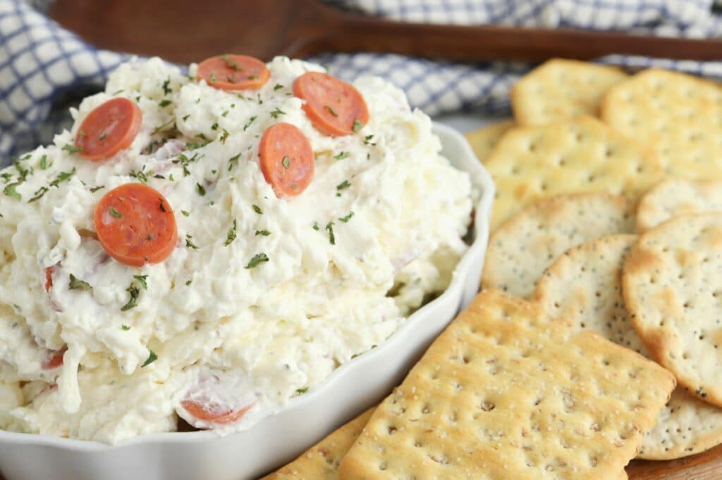 A bowl of cheese dip with crackers and crackers.