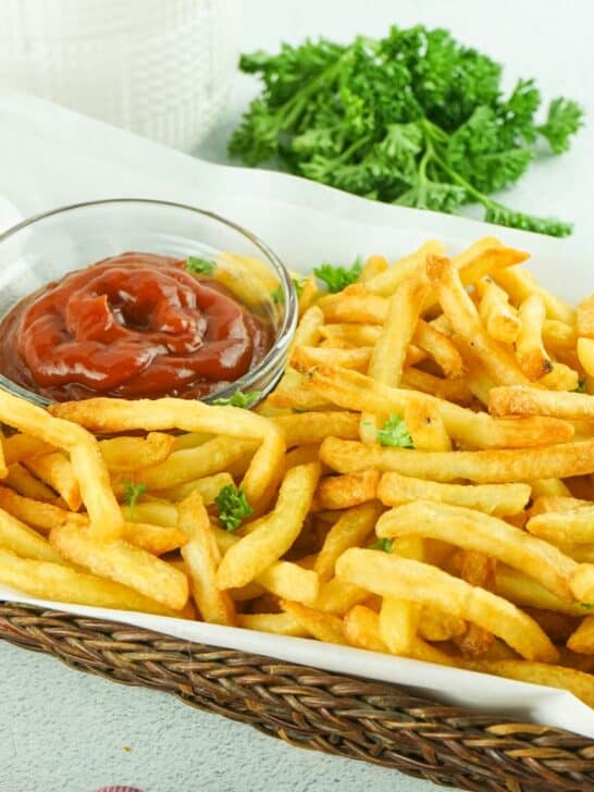 French fries in a basket with ketchup.