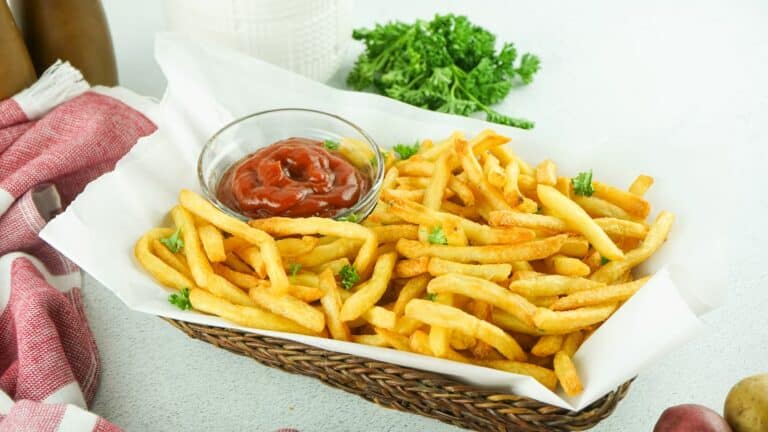 French fries in a basket with ketchup.