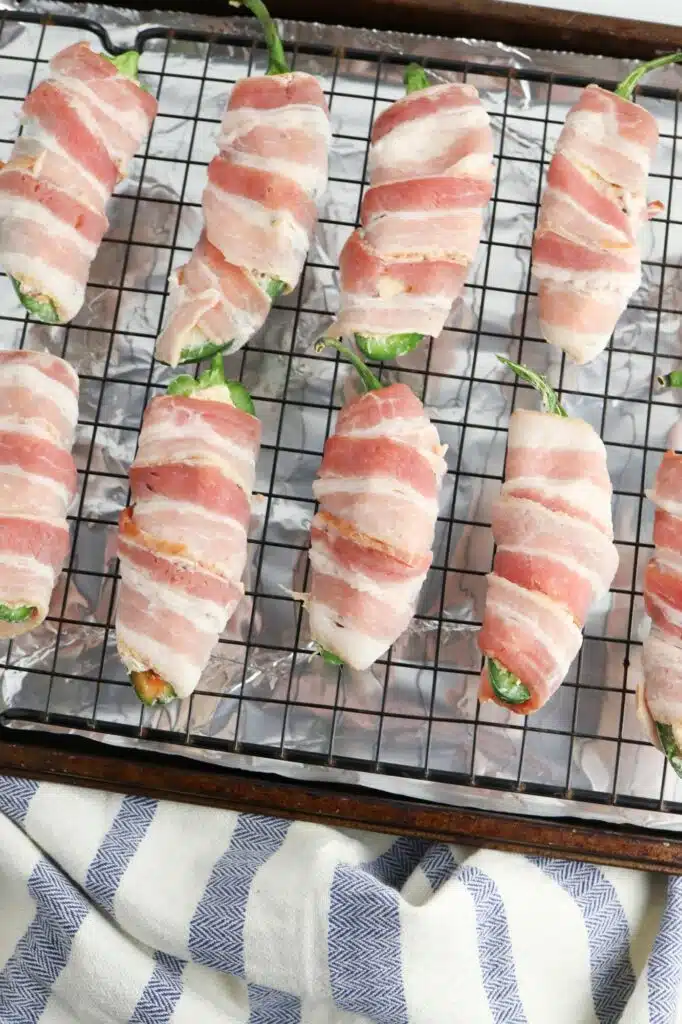 Bacon wrapped peppers on a cooling rack.