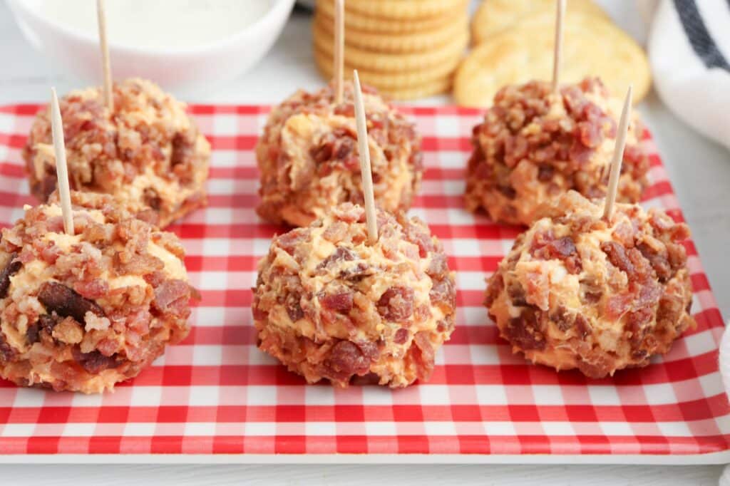 Bacon cheese balls on a red and white checkered plate.