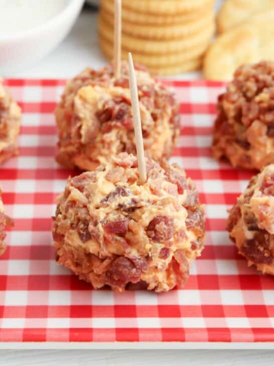 Bacon cheese balls on a red and white checkered plate.