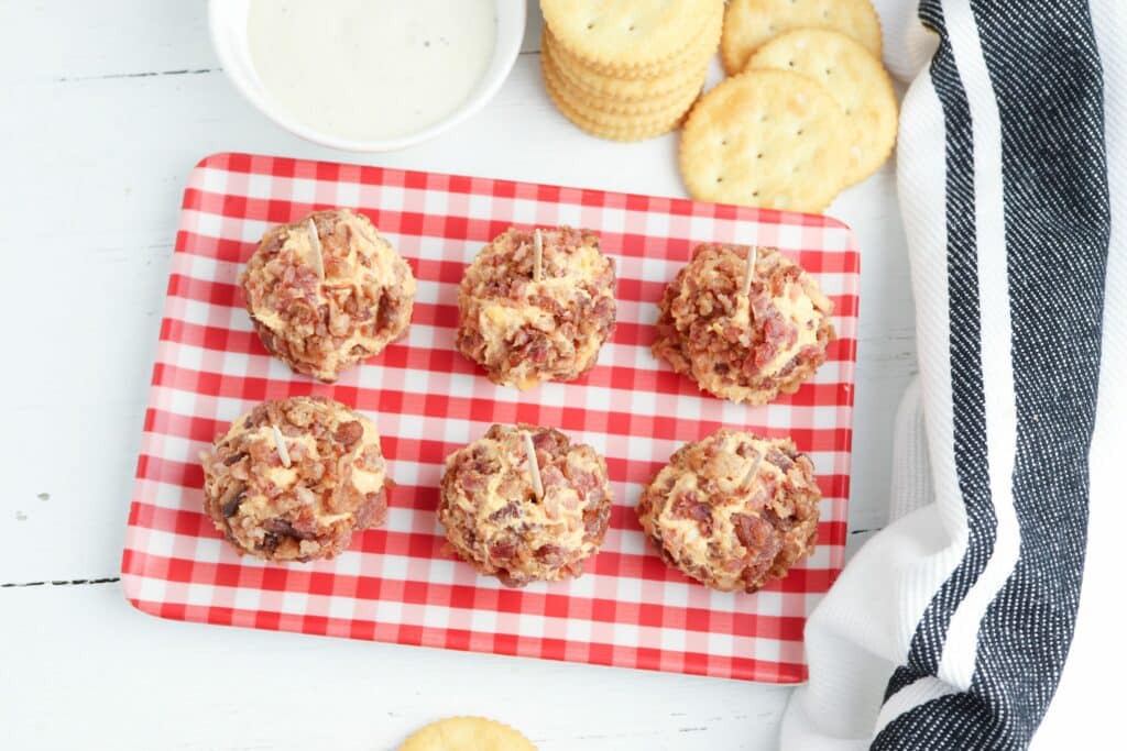 Bacon cheese balls on a red and white checkered plate.