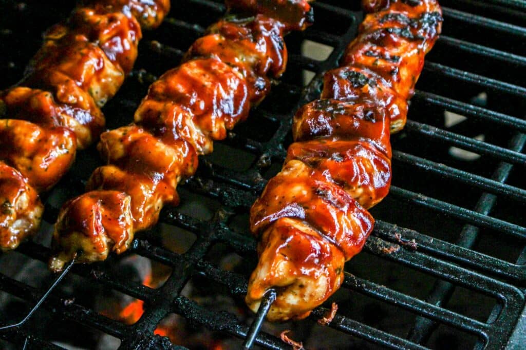 Bbq chicken skewers on a grill.