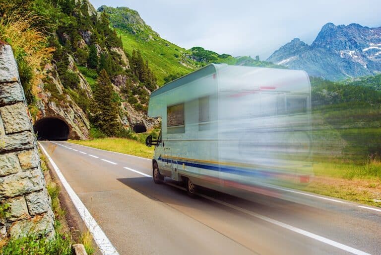 Class C RV speeding down a mountain highway into a tunnel