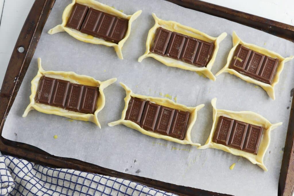 Chocolate bar tarts on a baking sheet.