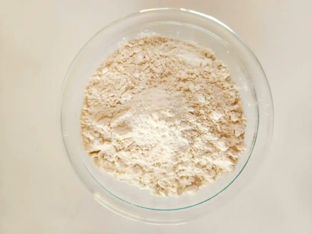 Flour in a glass bowl on a white background.