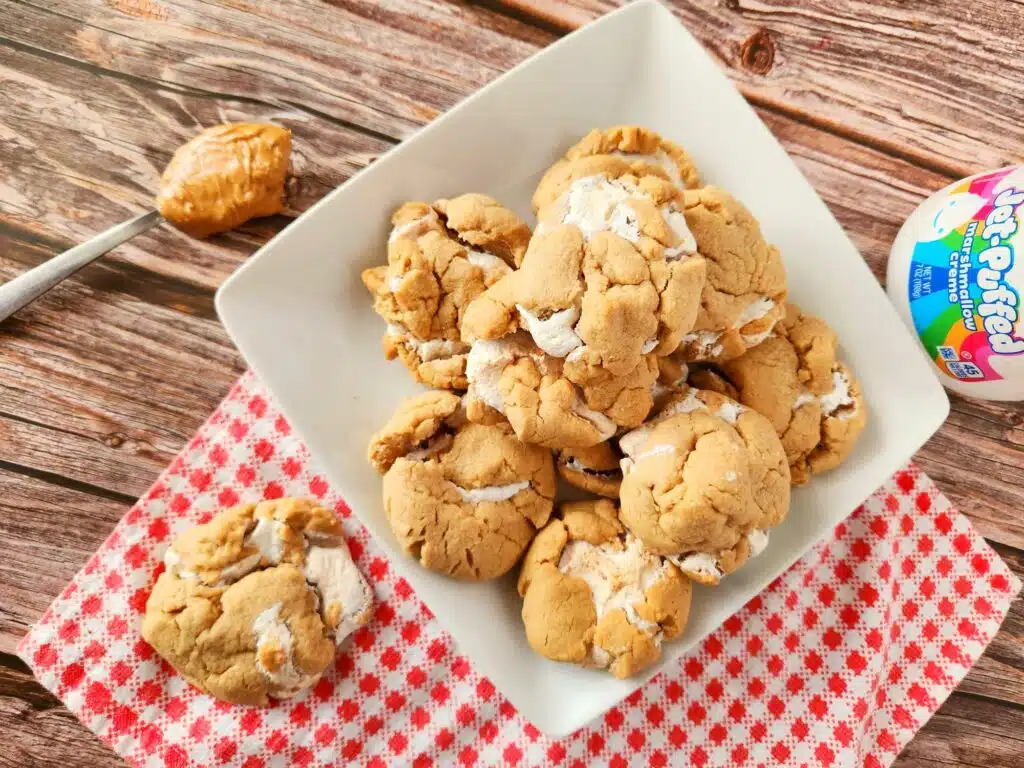 A white plate with cookies and peanut butter on it.