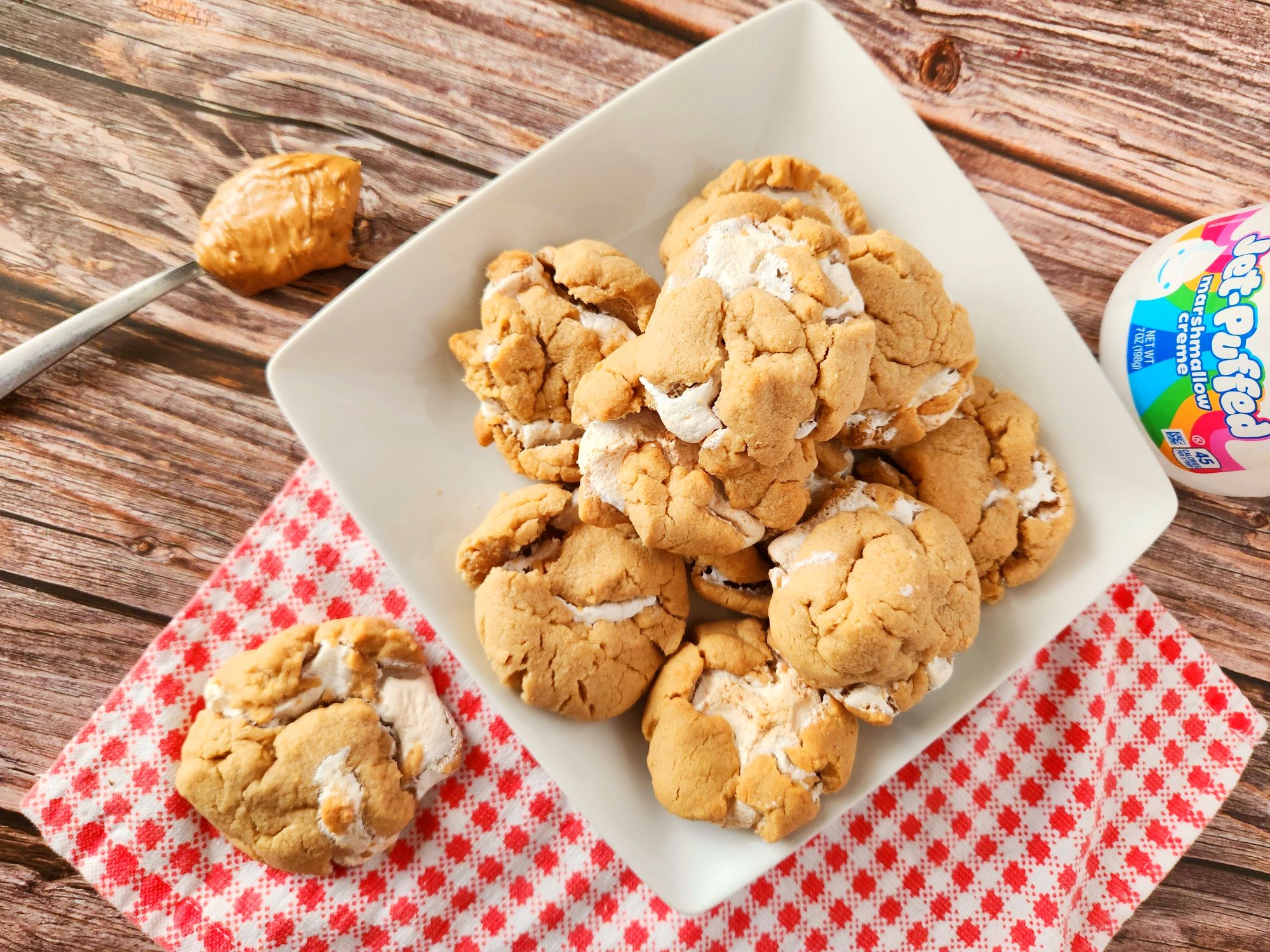 A white plate with cookies and peanut butter on it.