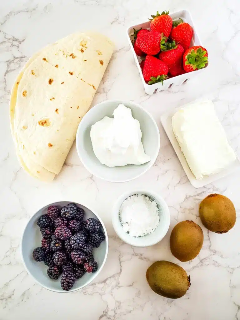 Ingredients for a berry and kiwi breakfast burrito.