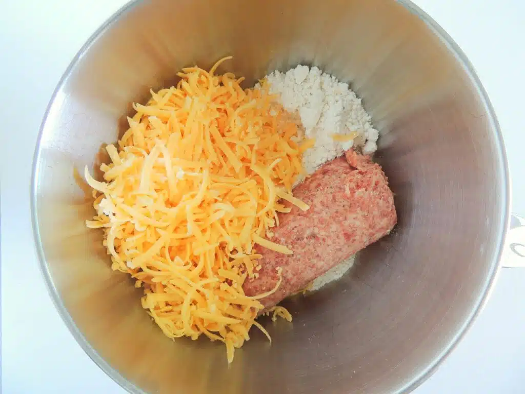 Meatballs and cheese in a mixing bowl.