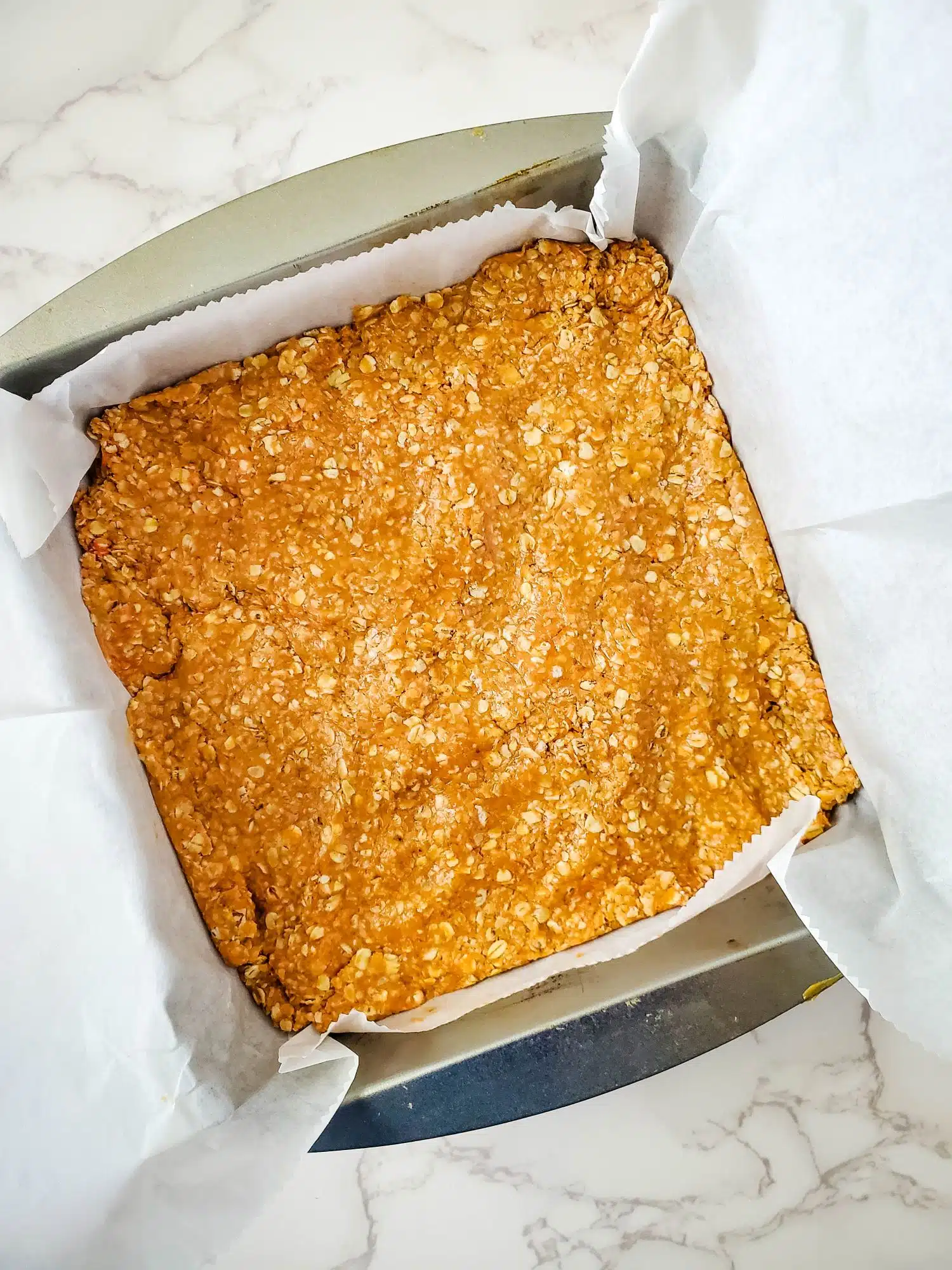 A square of granola in a baking pan.