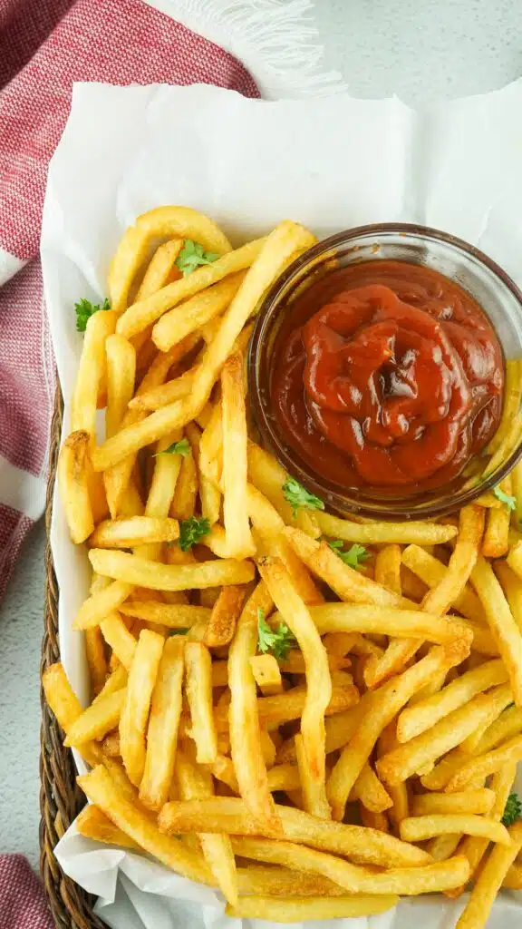French fries in a basket with ketchup.
