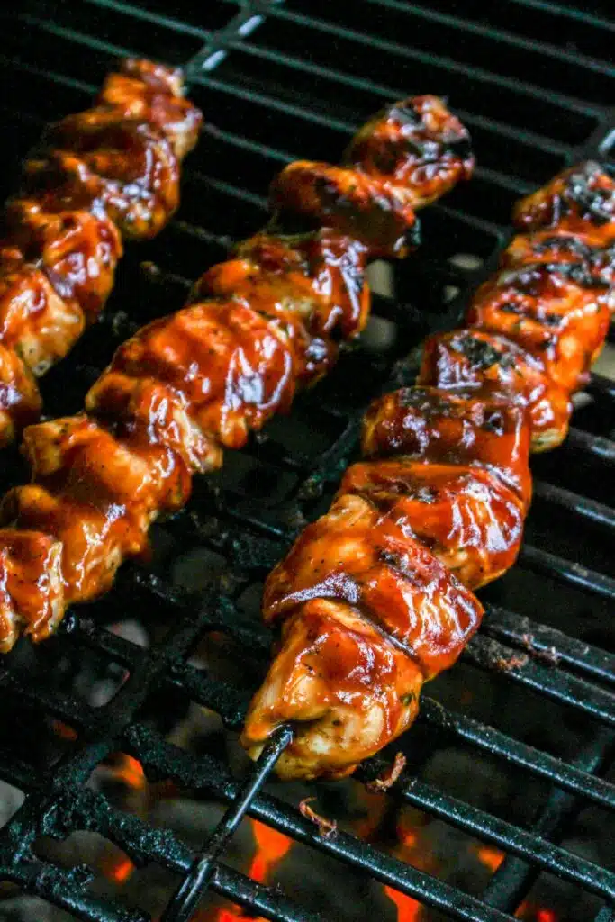 Bbq chicken skewers on a grill.