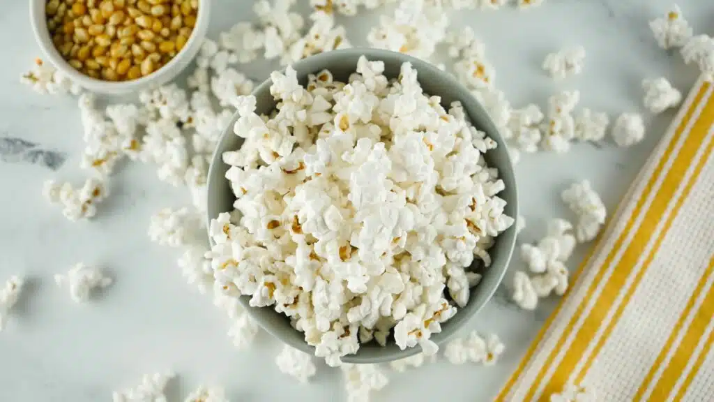 Popcorn in a bowl on a white table.