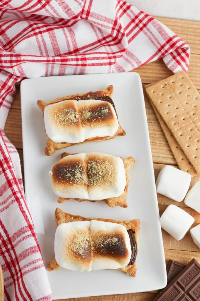 Three s'mores pies on a white plate.