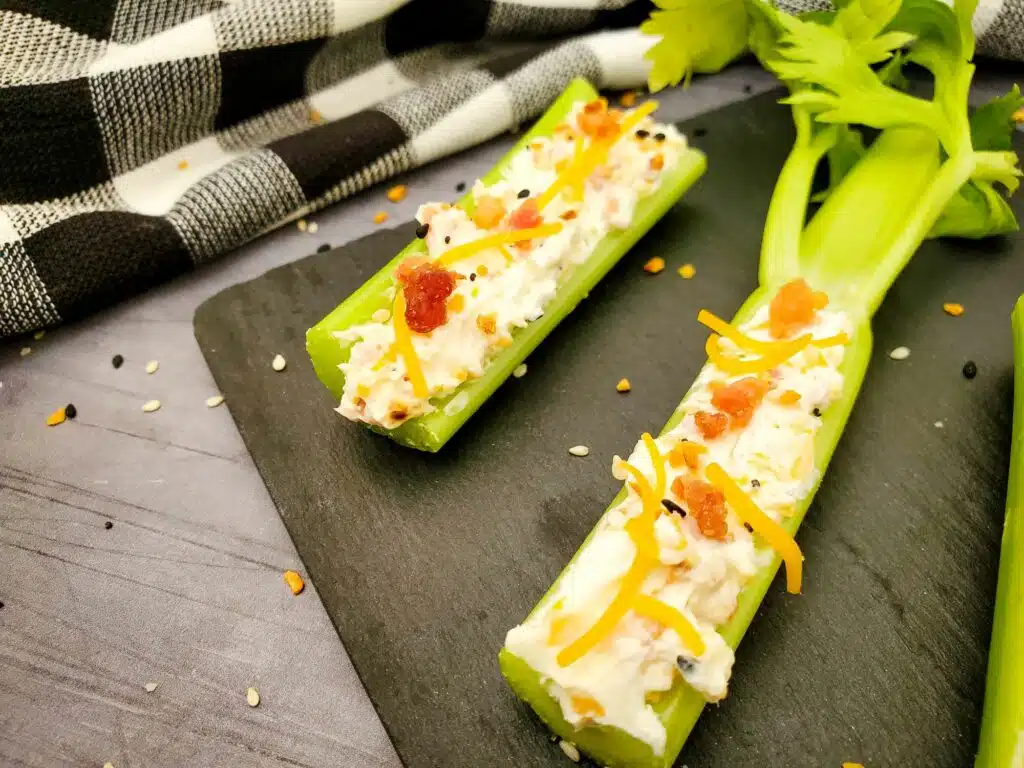 Celery sticks with cheese and bacon on a plate.