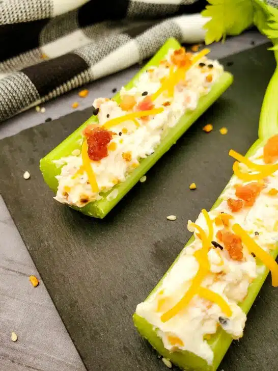 Celery sticks with cheese and bacon on a plate.