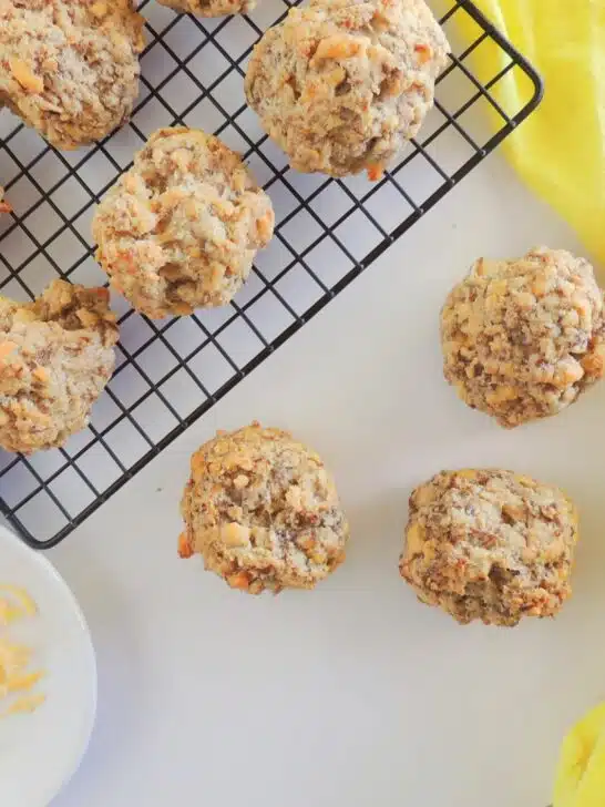 Cheesy meatballs on a cooling rack.