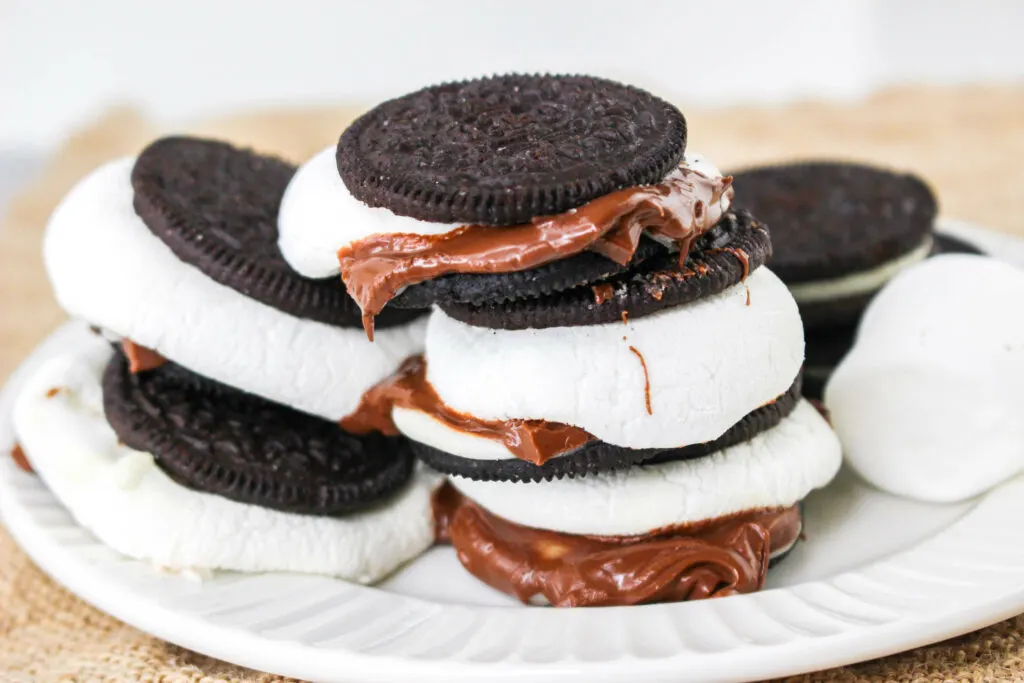 Plate of cookie sandwiches filled with marshmallow and chocolate spread.